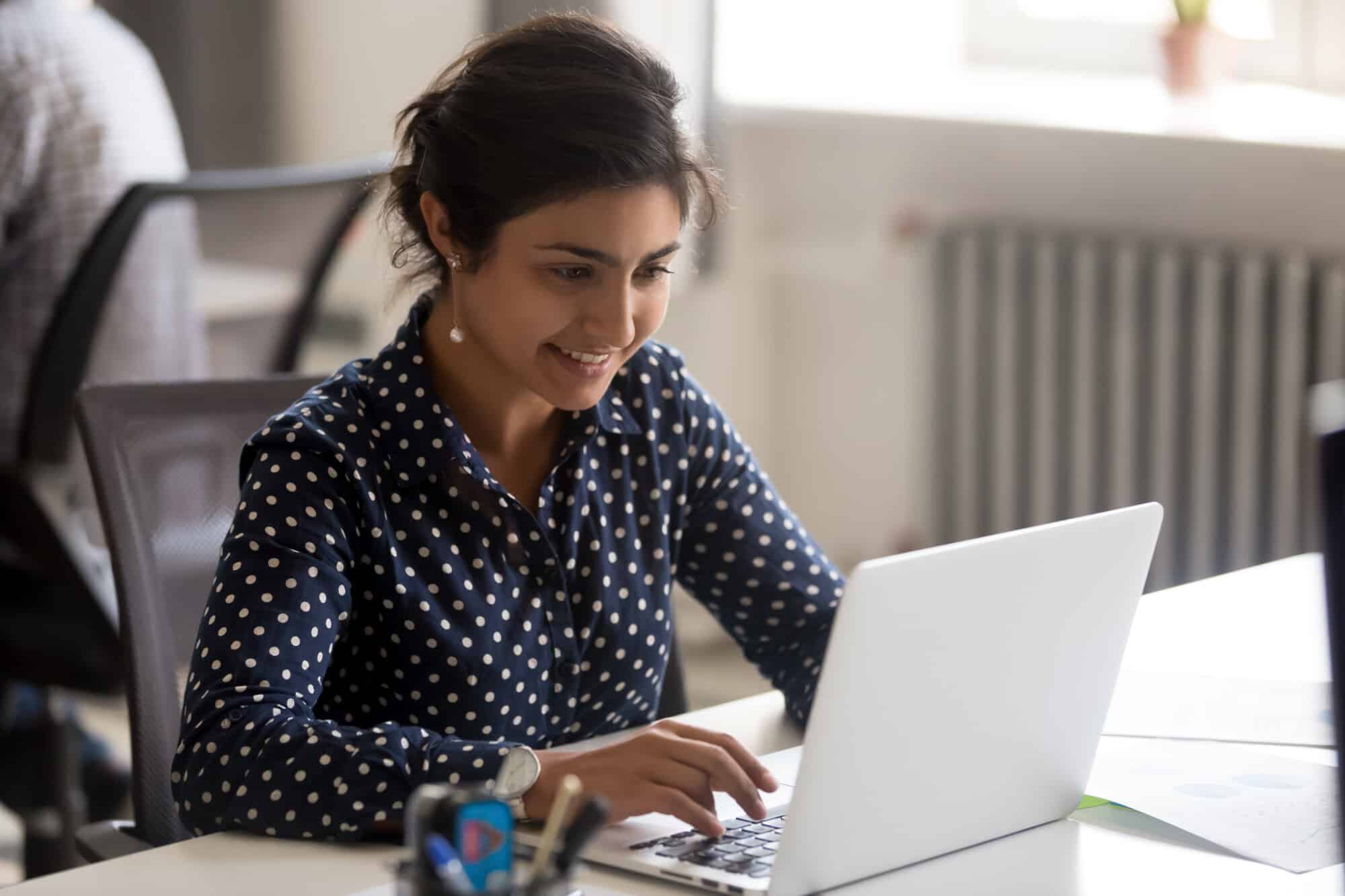 Smiling virtual assistant at a computer using microsoft teams