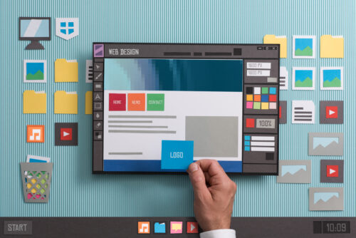 A person’s hand holds a digital tablet displaying a web design interface. The screen shows navigation buttons, a logo, and color palette tools. Explore an array of virtual assistant software tools amid colorful digital icons and folders on a striped surface in the background.